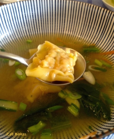 Pork and ginger wontons in broth with choy and spring onions